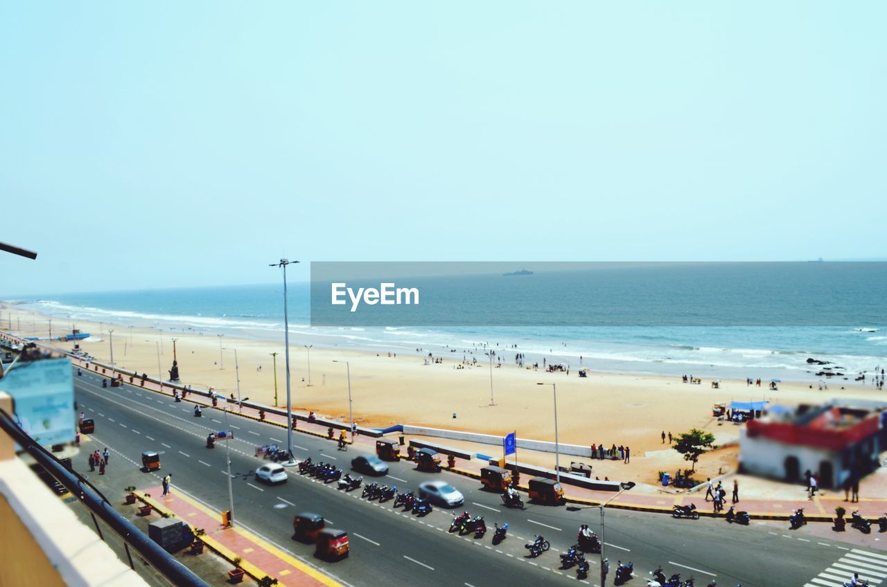 HIGH ANGLE VIEW OF CROWD ON BEACH AGAINST SKY