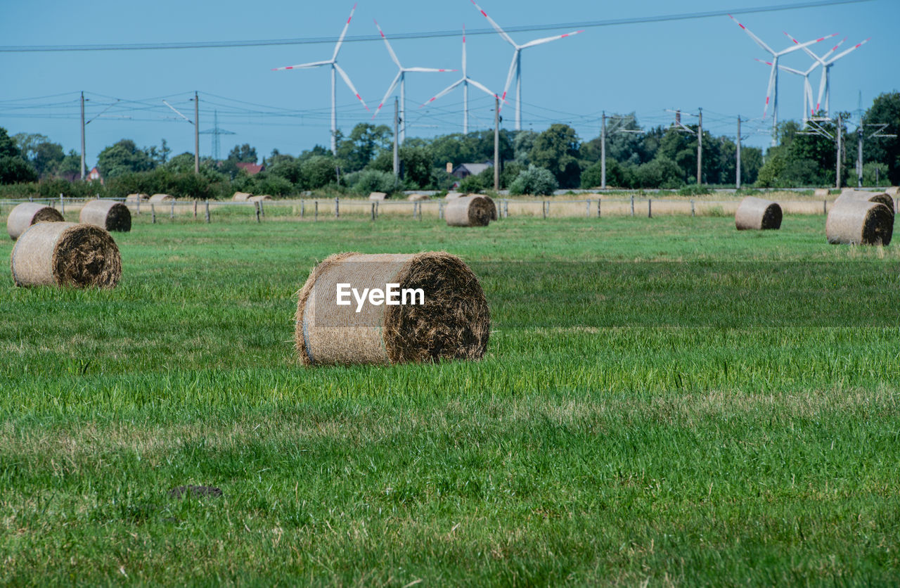 Hay bales on field against sky