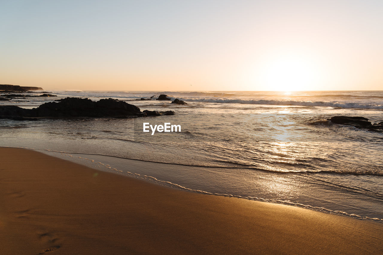 Scenic view of sea against clear sky during sunset