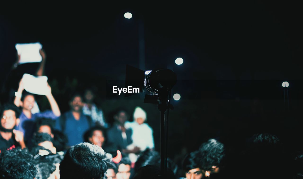 People photographing at music concert during night