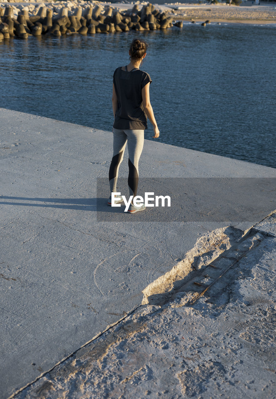 FULL LENGTH REAR VIEW OF WOMAN STANDING ON SHORE