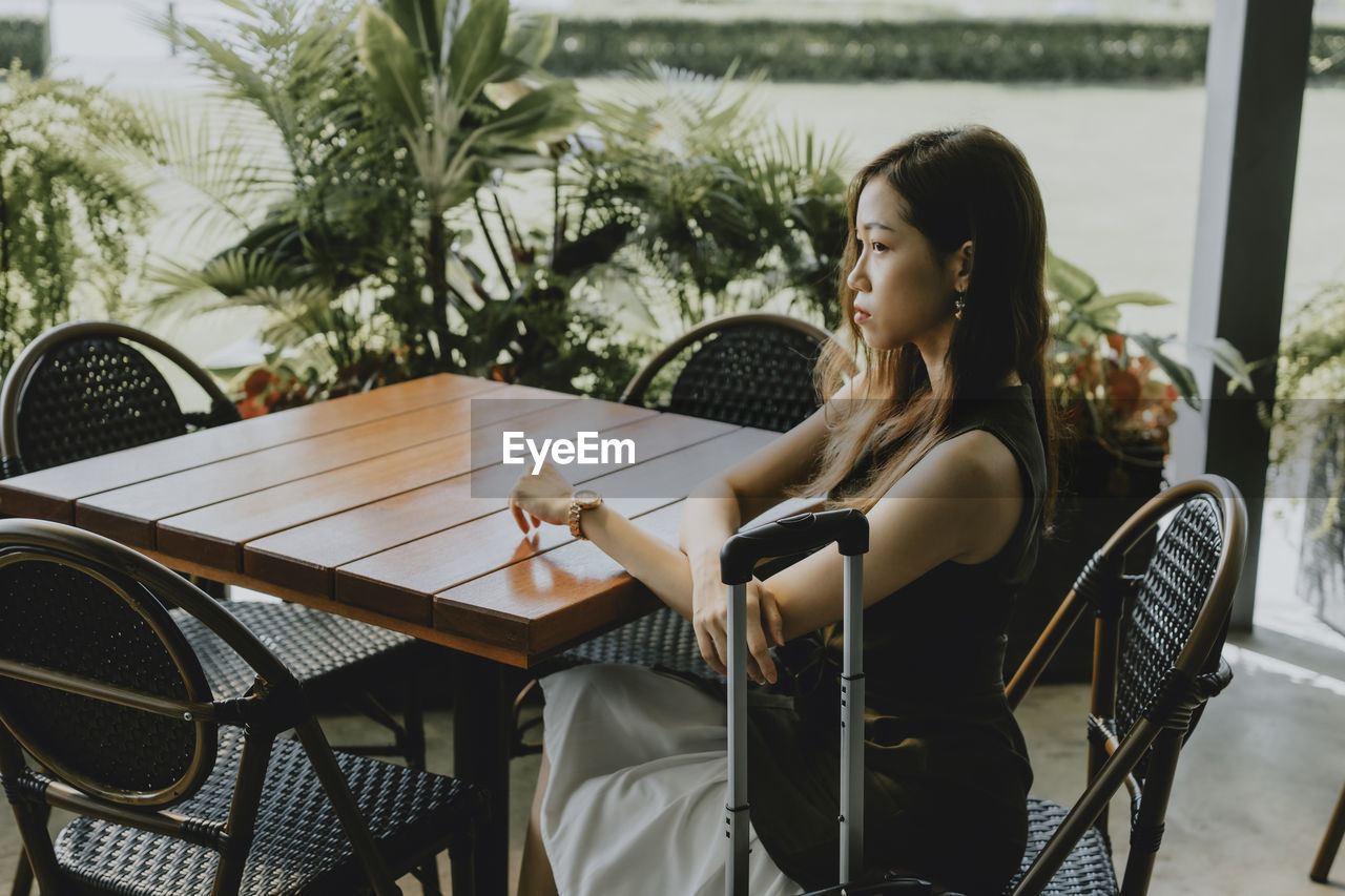 WOMAN SITTING ON CHAIR