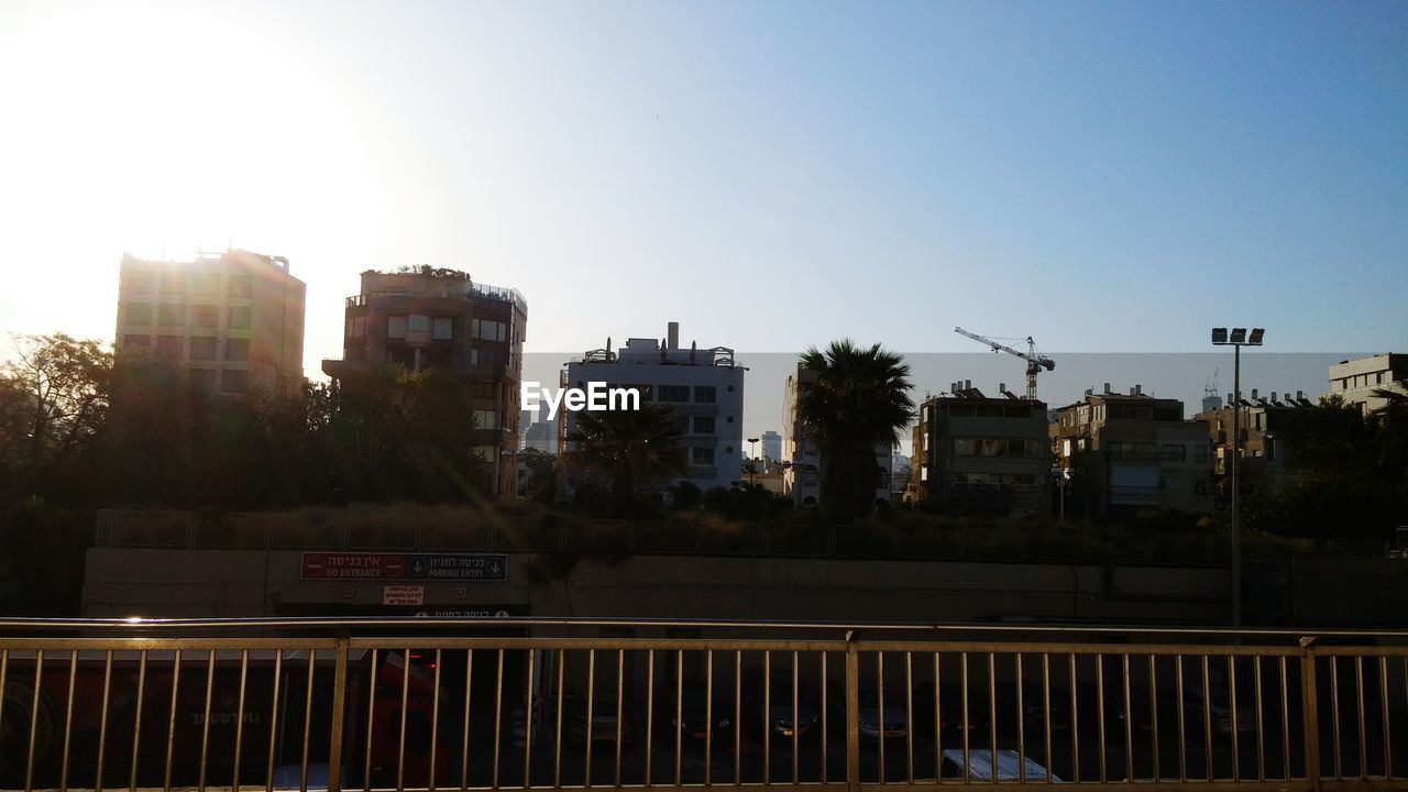 View of city buildings against sun