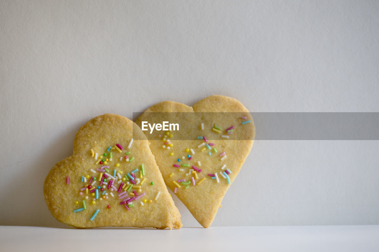 CLOSE-UP OF COOKIES ON PAPER AGAINST WHITE BACKGROUND