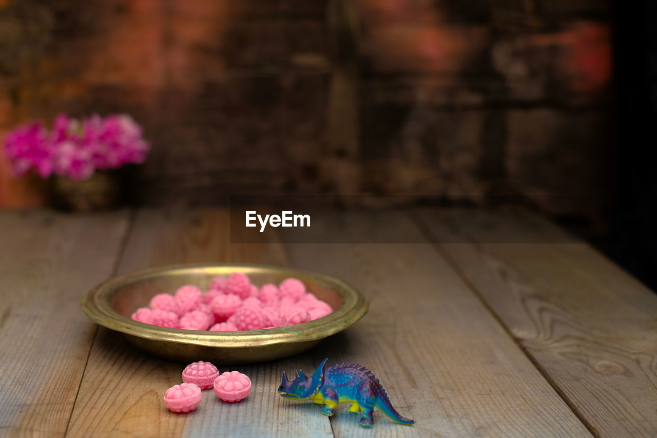 CLOSE-UP OF PINK ROSE ON TABLE