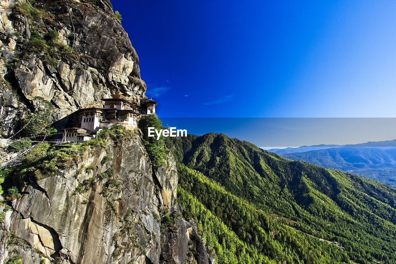 Scenic view of tigers nest monastery with mountains against blue sky