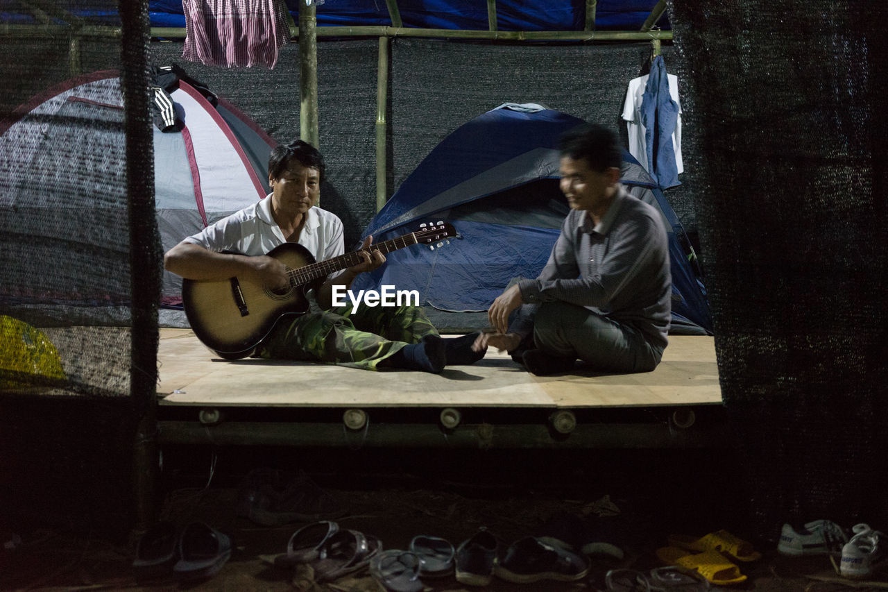 sitting, two people, full length, traditional clothing, real people, playing, togetherness, day, outdoors, young adult