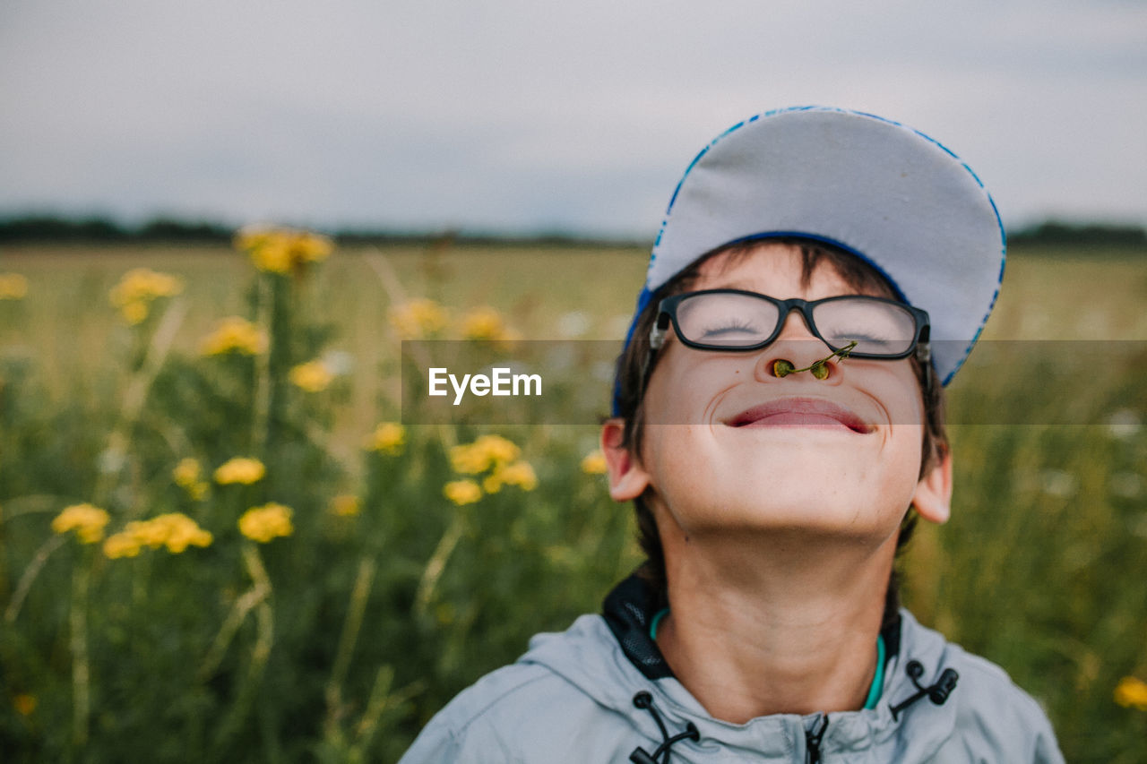 Smiling boy with buds in nose wearing eyeglasses