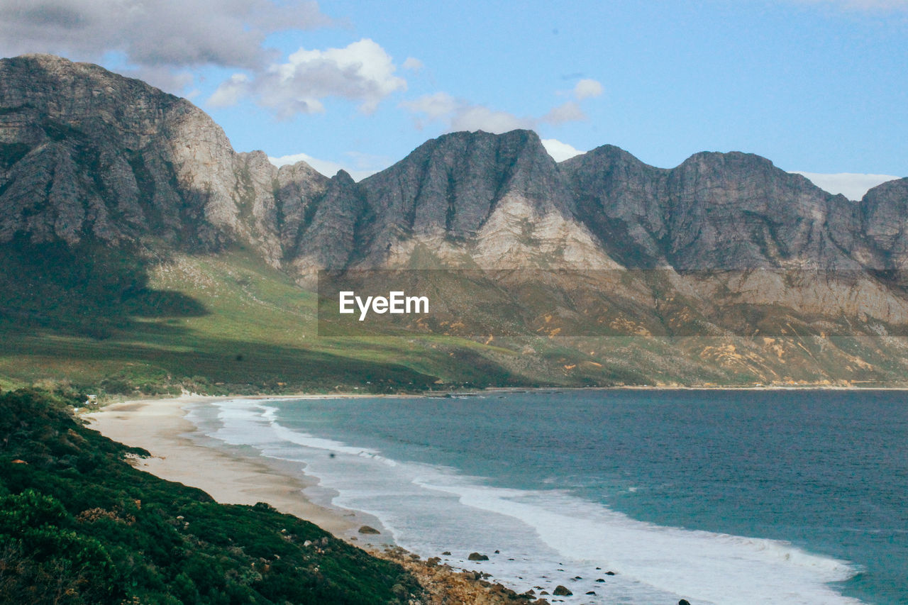 SCENIC VIEW OF BEACH AGAINST MOUNTAINS