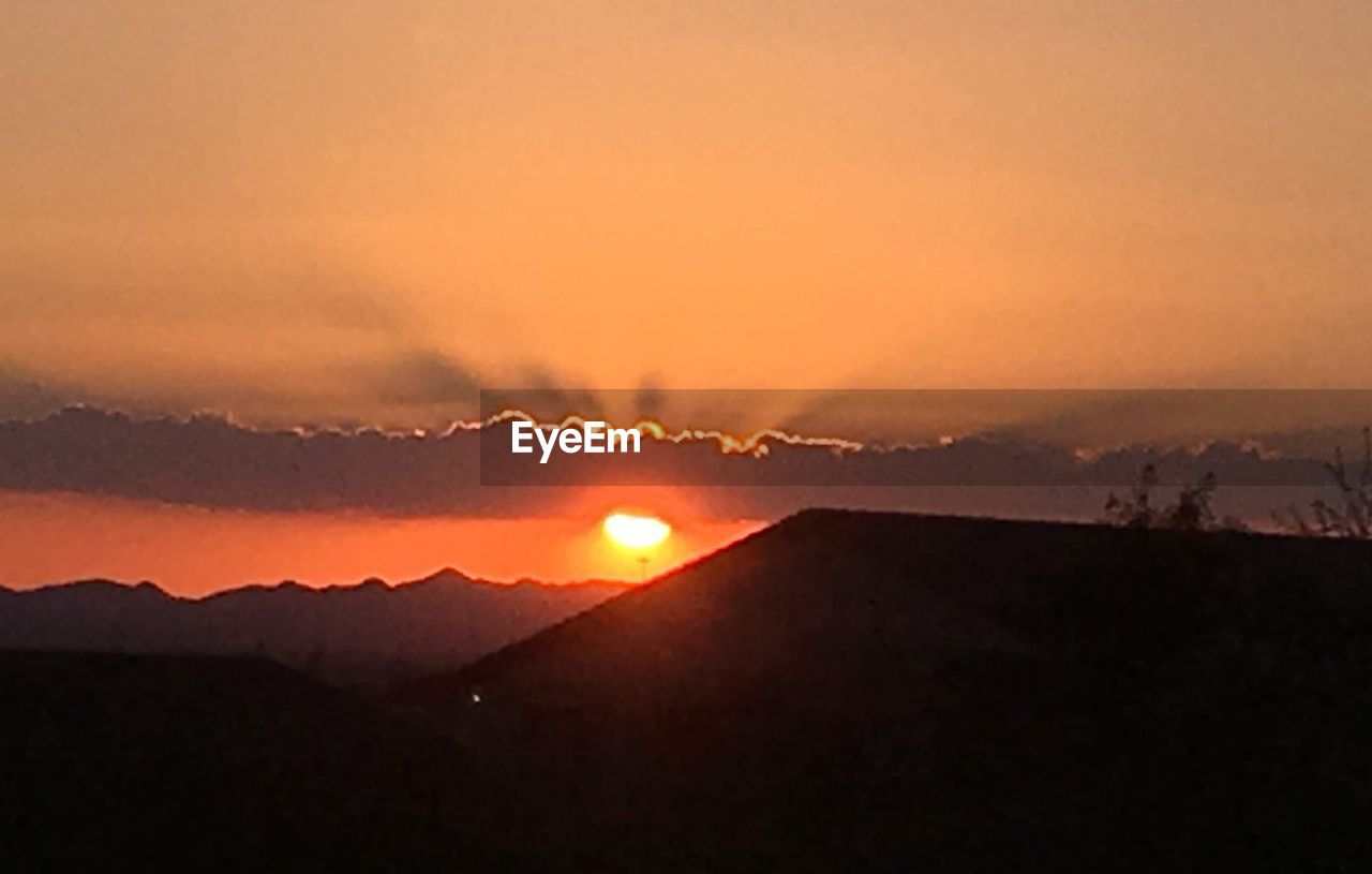 SCENIC VIEW OF SILHOUETTE MOUNTAINS AGAINST ROMANTIC SKY