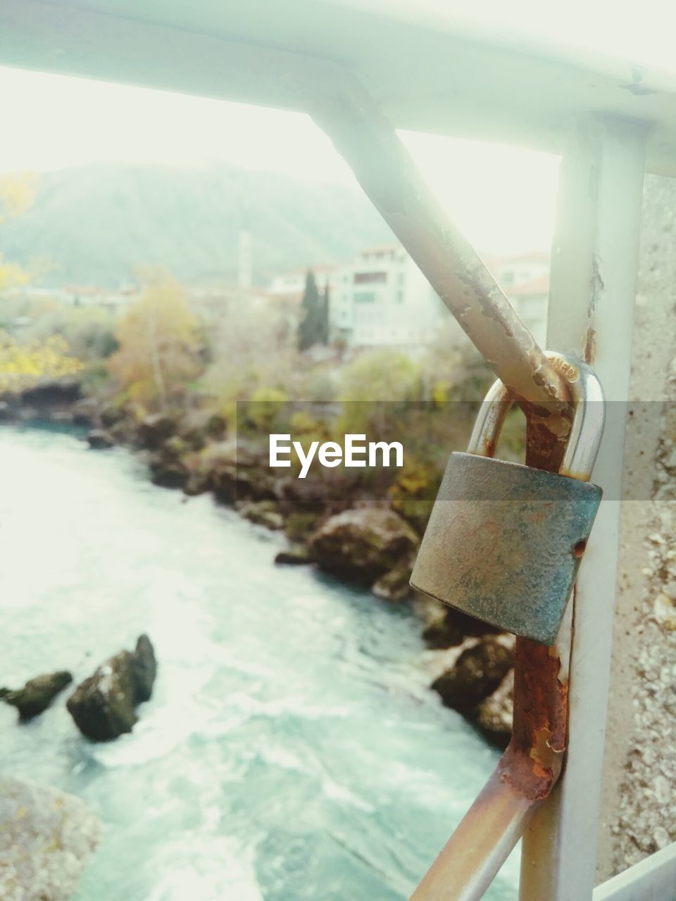 CLOSE-UP OF PADLOCKS ON RAILING AGAINST SKY