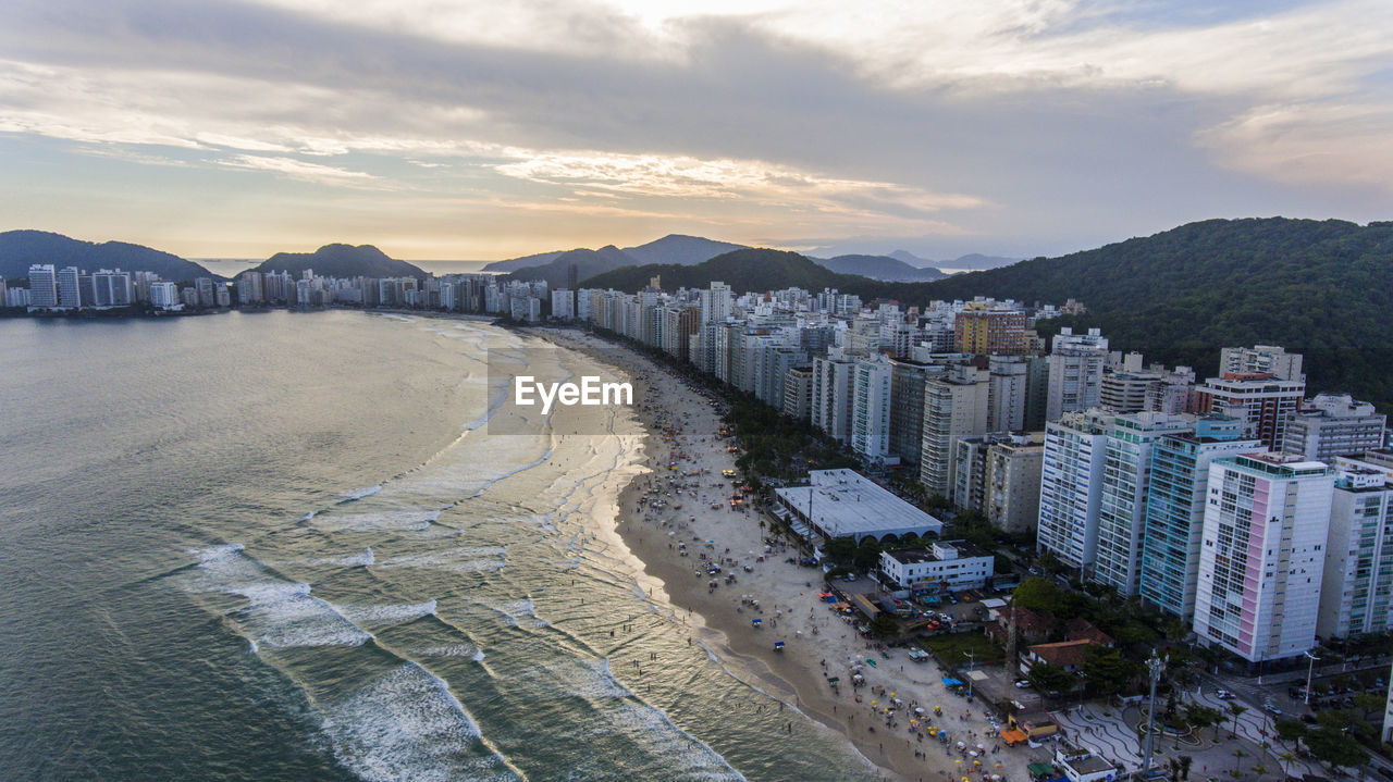 Panoramic view of beach and buildings against sky during sunset