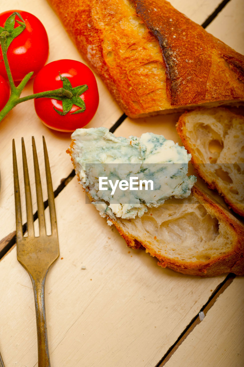 Fresh blue cheese spread ove french baguette with cherry tomatoes on side