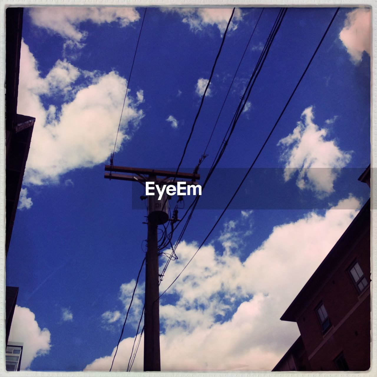 LOW ANGLE VIEW OF POWER LINES AGAINST CLOUDY SKY