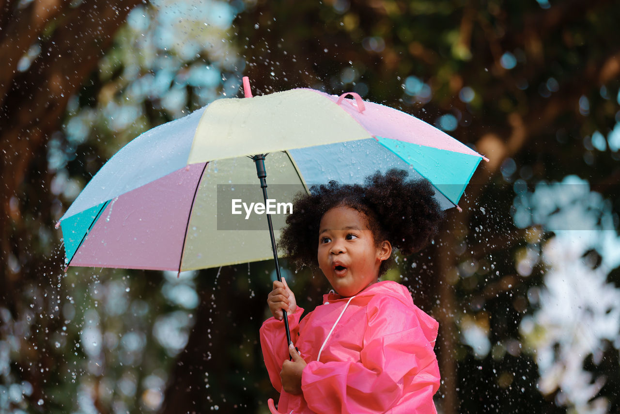 Cute girl holding umbrella outdoors