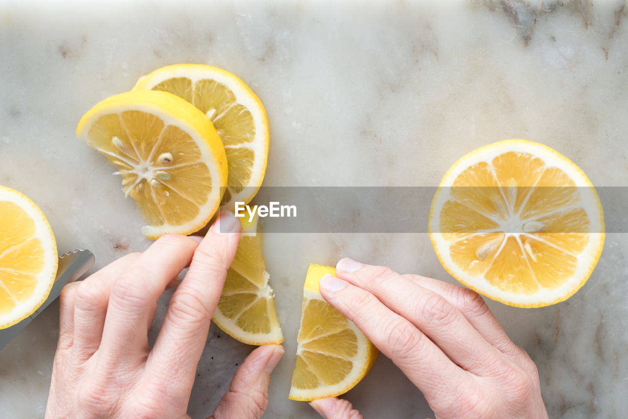 Cropped image of hand holding lemon on table