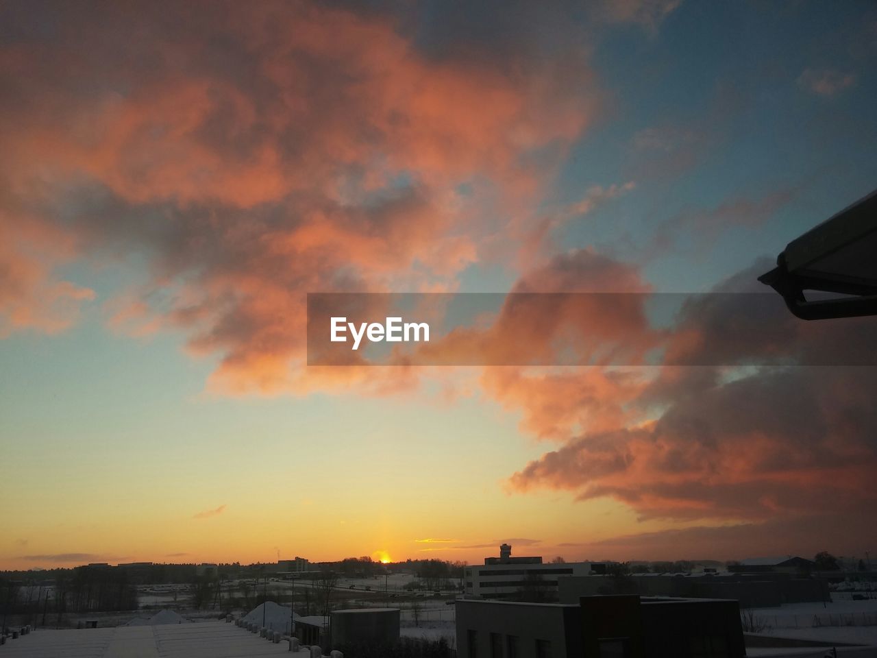 Cityscape against cloudy sky during sunrise