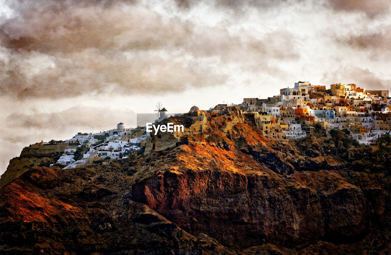 Rock formations by buildings against sky