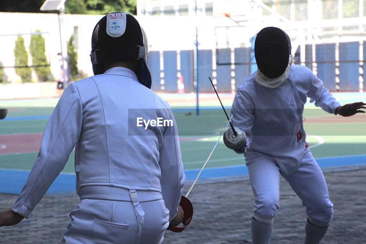 Rear view of man get ready for fencing sports.  