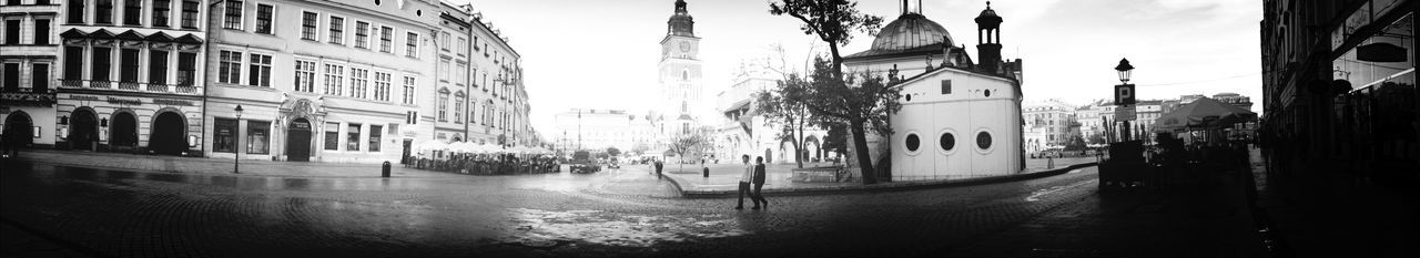 Panoramic view people walking on street against buildings in city