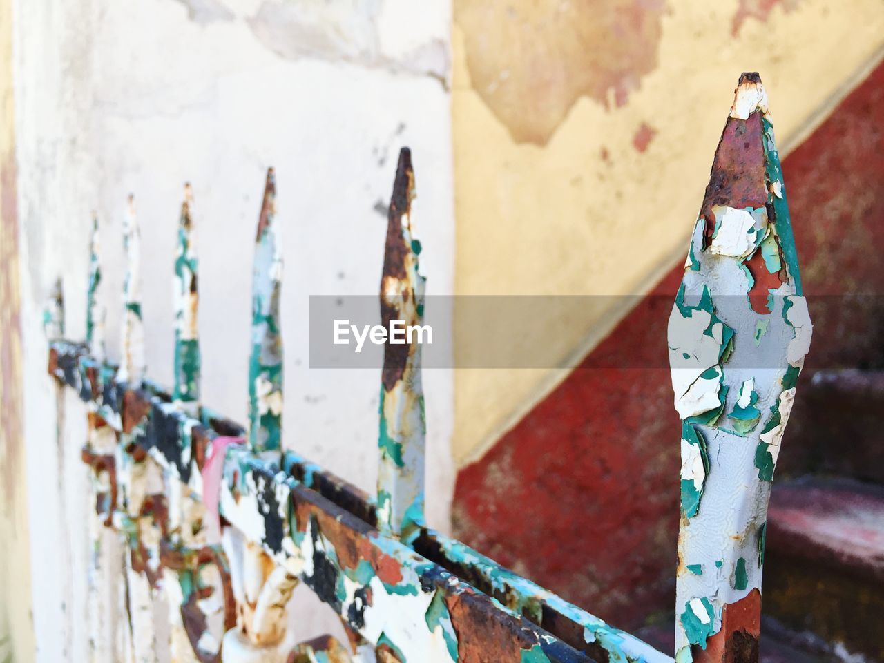 Close-up of rusty metallic fence against building