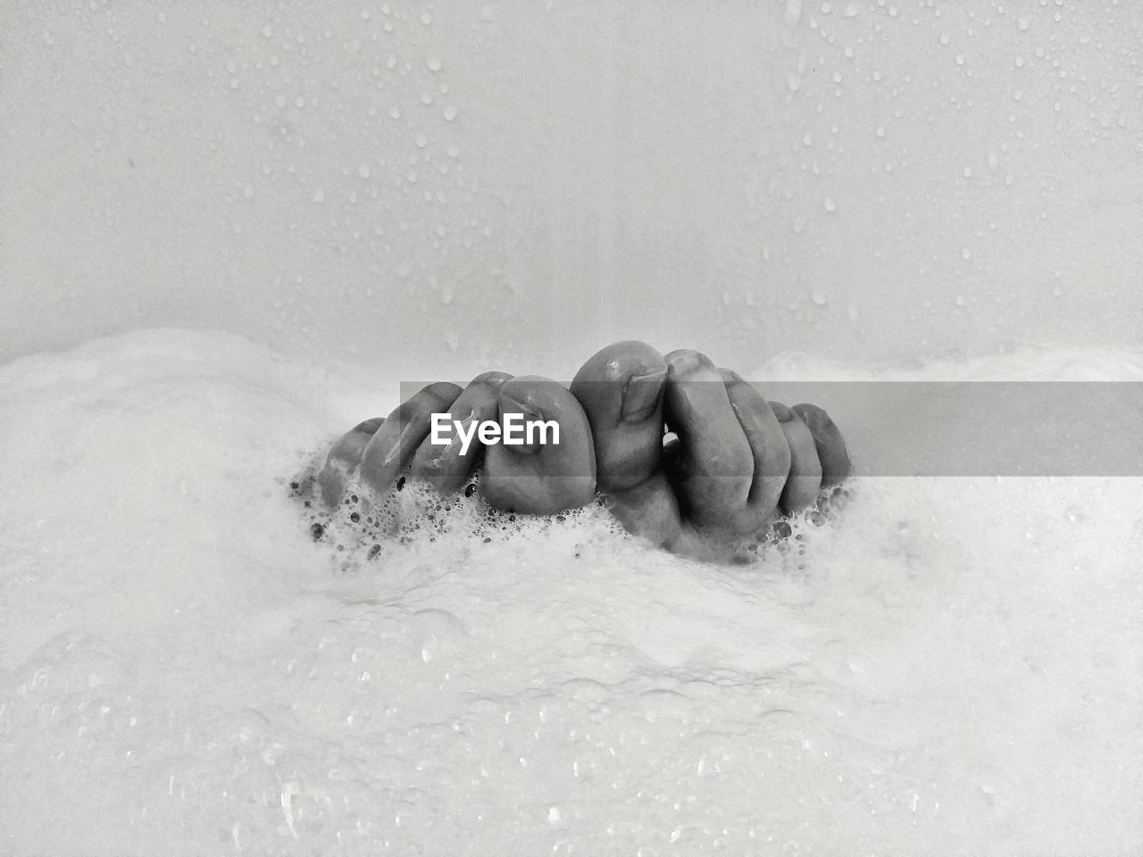 Low section of person taking bubble bath in bathroom