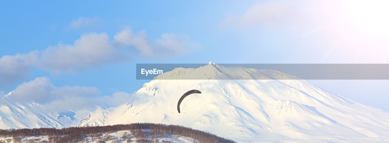 Paraglider flying against the background of volcano on kamchatka peninsula