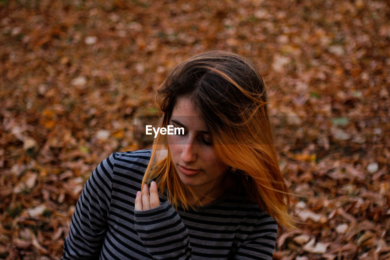 High angle view of teenage girl standing in park during autumn