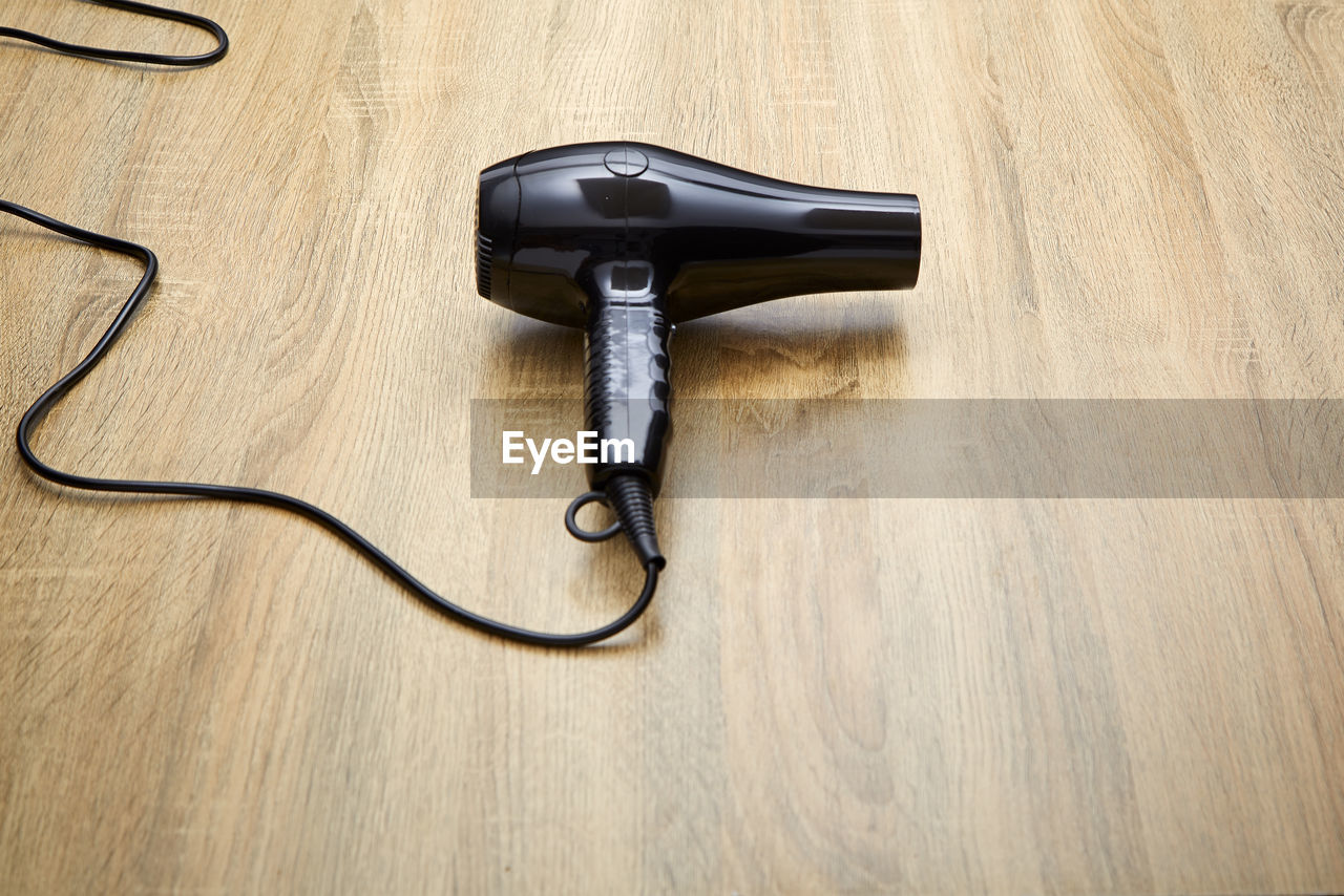 High angle view of hair dryer on wooden table