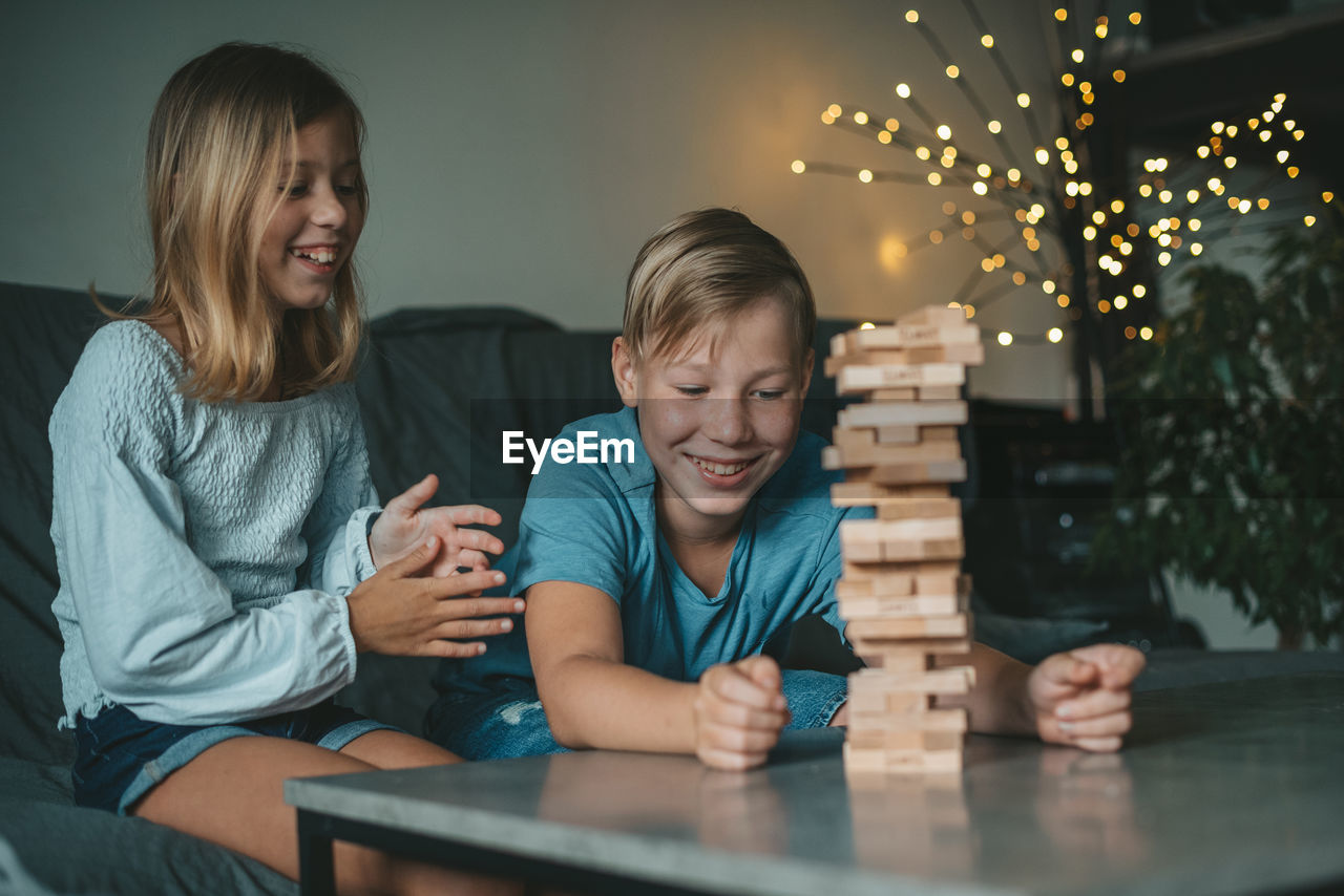 Portrait of happy friends sitting on table at home