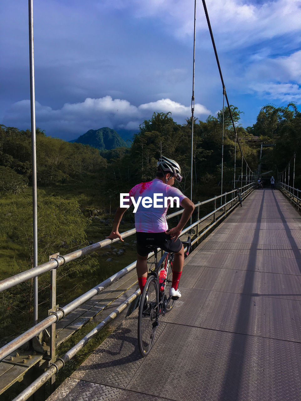 Rear view of man riding bicycle on road