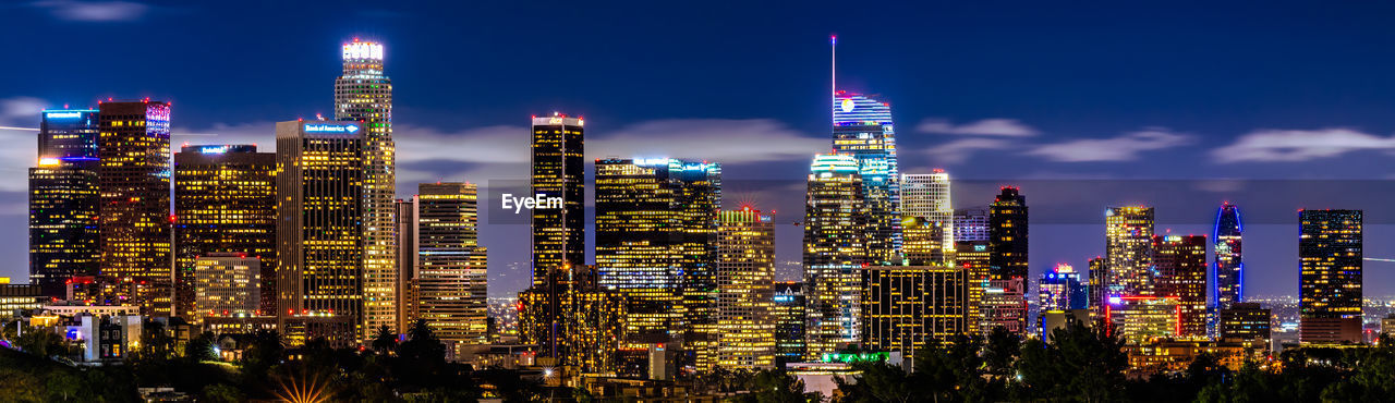Illuminated cityscape against sky at night