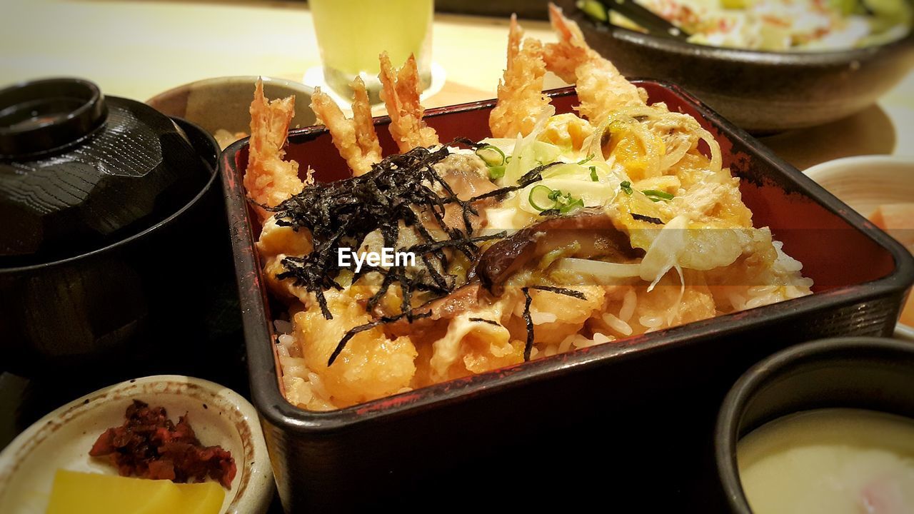 High angle view of tempura prawns over rice on table