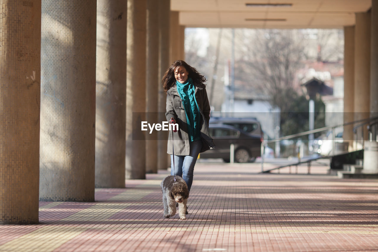 Woman walking with dog on colonnade