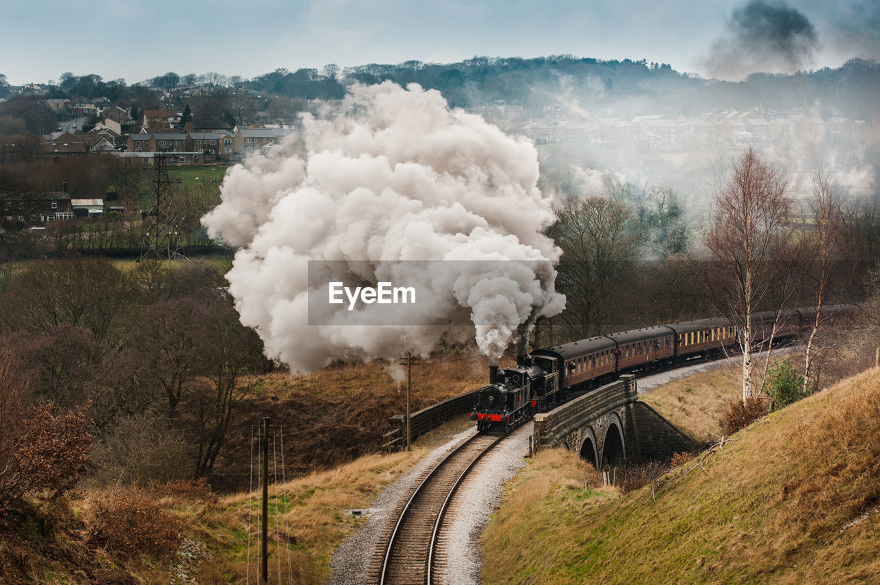 High angle view of train emitting smoke by trees