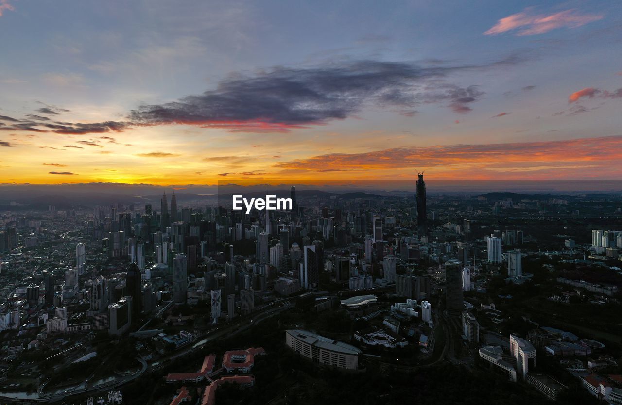 High angle view of modern buildings against sky during sunset