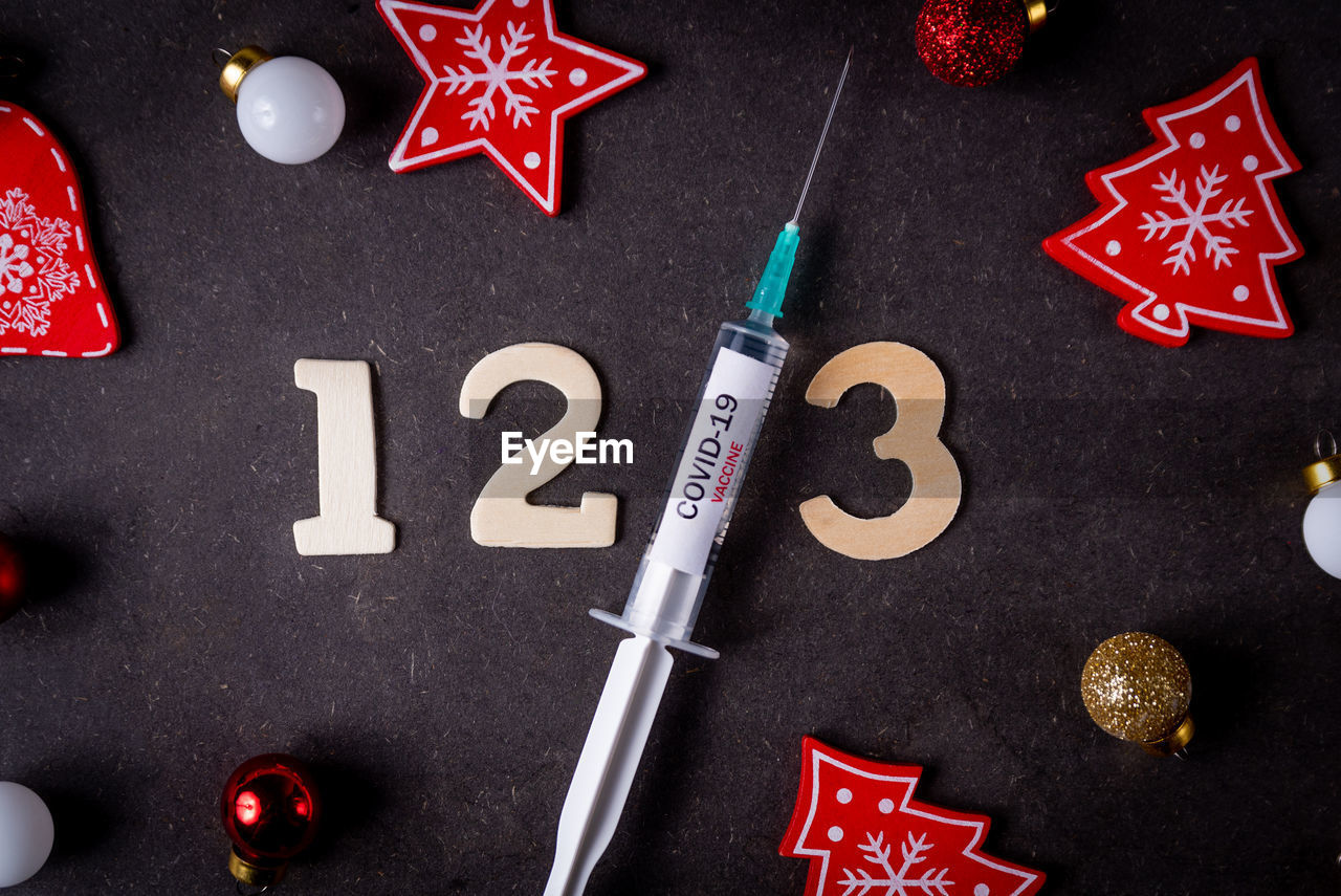 Third covid vaccine dose and jab concept and numbers and christmas decorations. syringe is seen