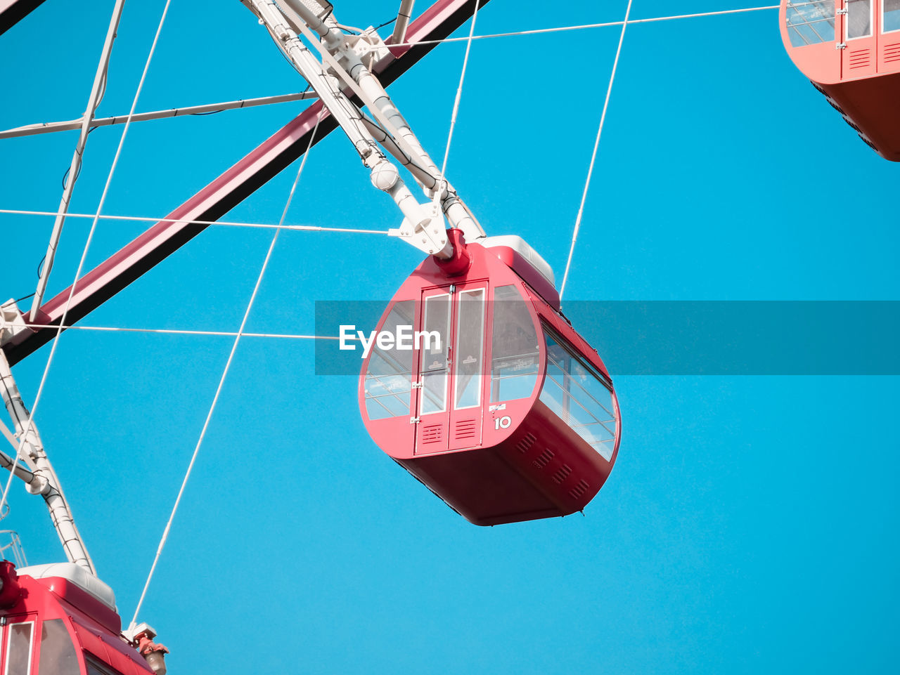 Low angle view of ferris wheel against blue sky