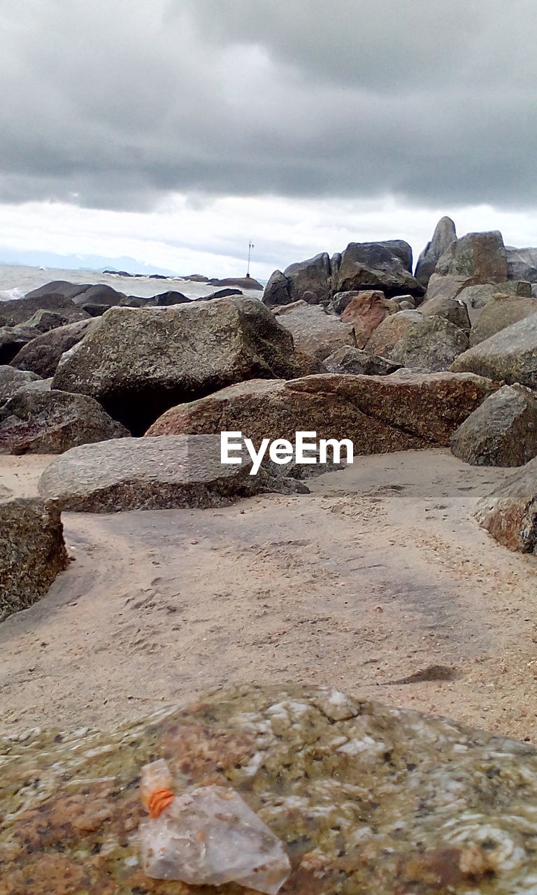 ROCKS ON SHORE AGAINST SKY