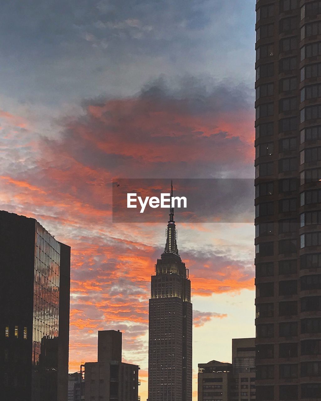 Low angle view of skyscrapers against dramatic sky