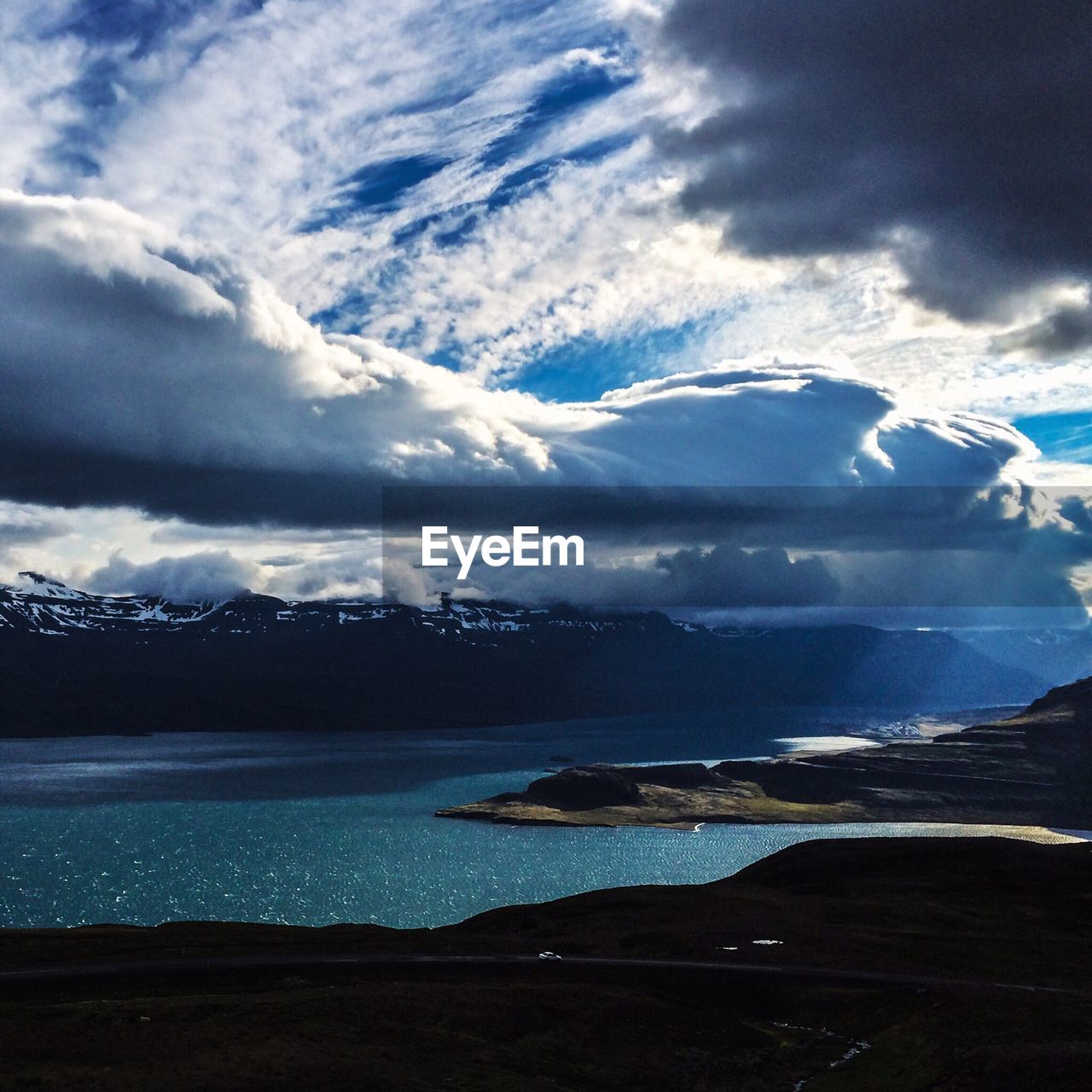 Scenic view of river against cloudy sky