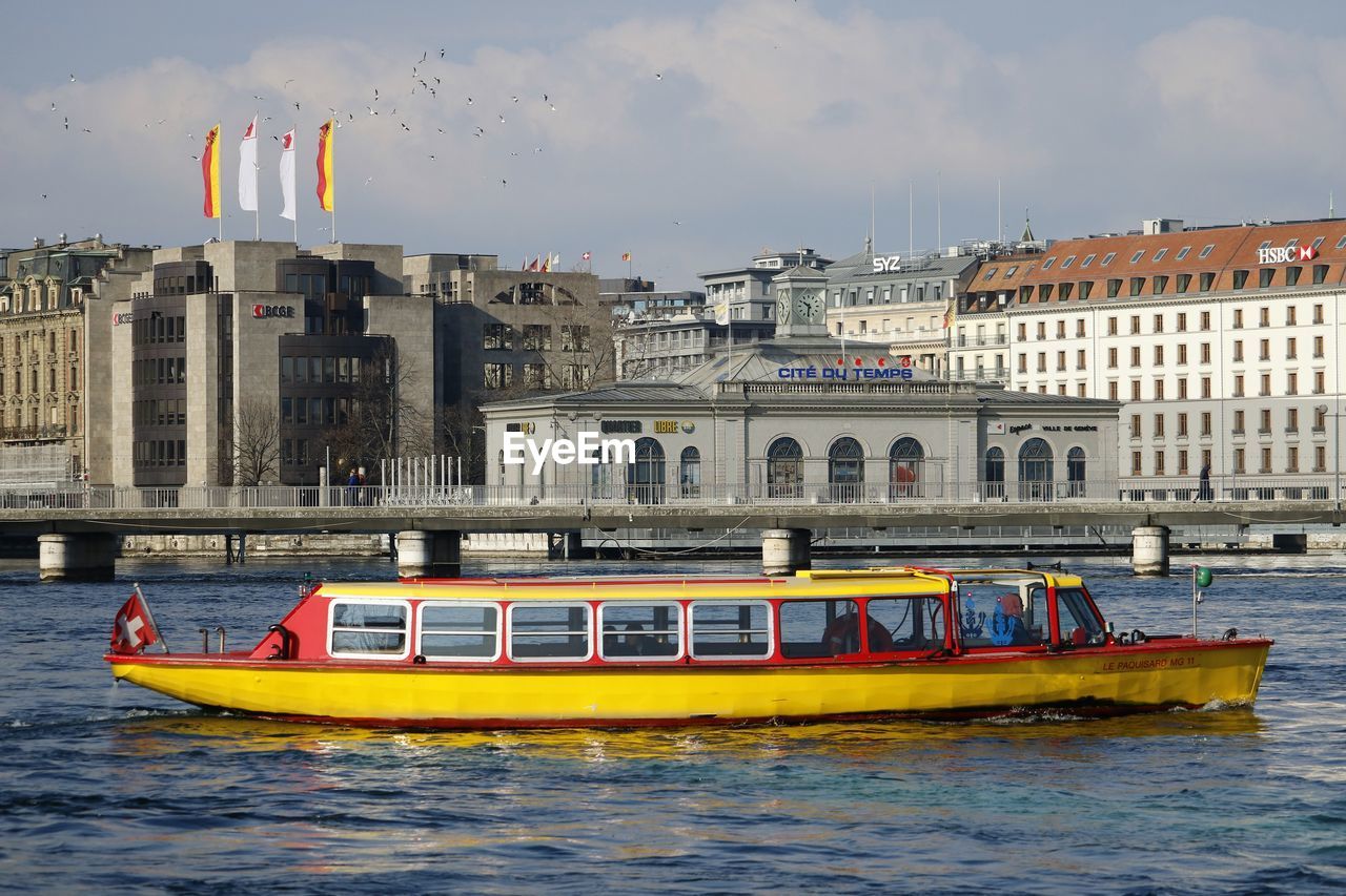 BOAT IN RIVER AGAINST BUILDINGS