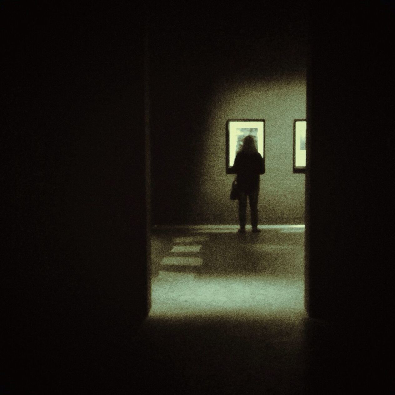 Rear view of woman watching painting in exhibition hall