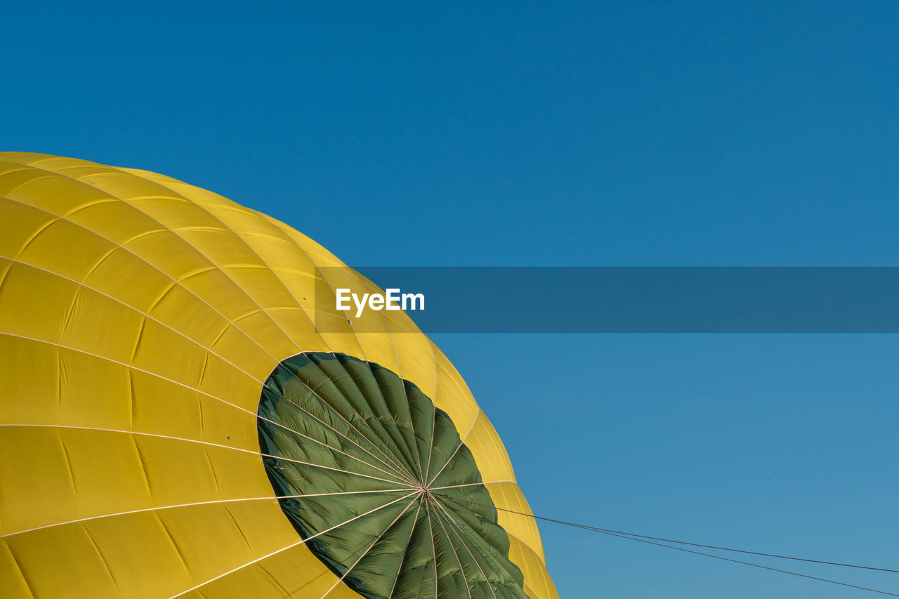 Low angle view of hot air balloon against clear blue sky