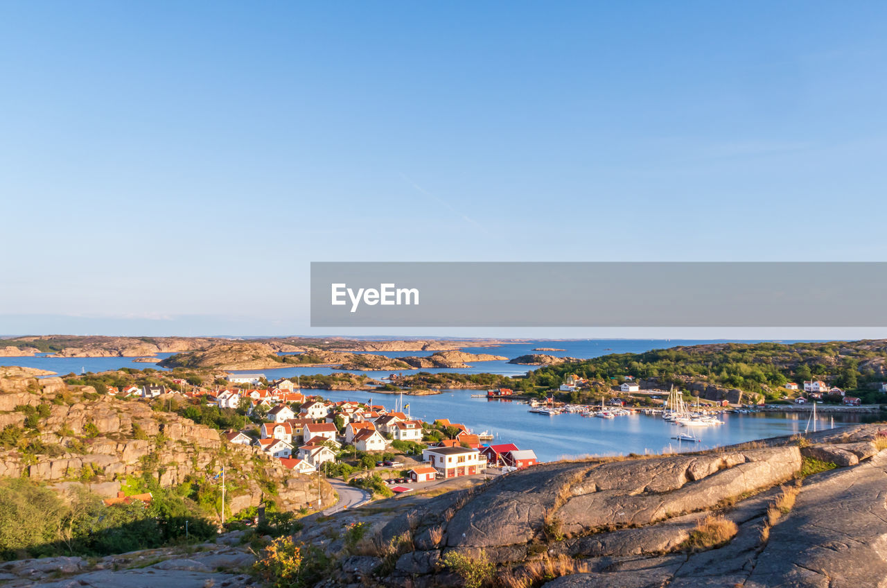 SCENIC VIEW OF SEA AND BUILDINGS AGAINST CLEAR SKY