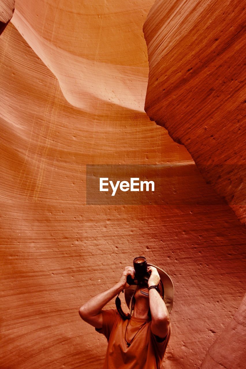 Man photographing amidst canyon