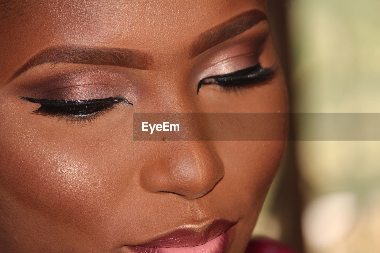 Close-up of woman wearing make-up at home