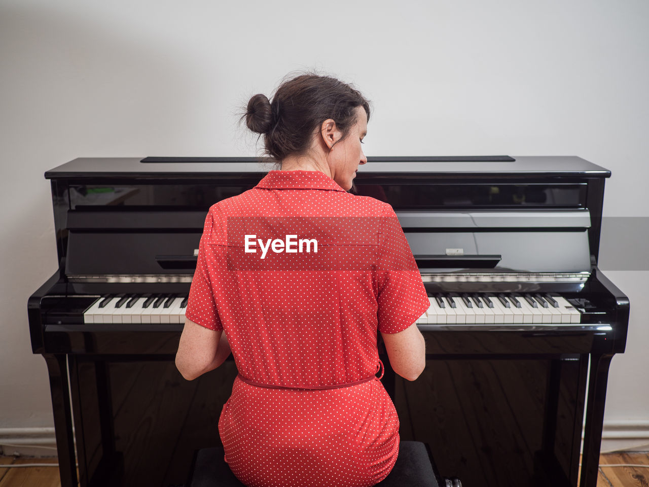 Rear view of woman playing piano