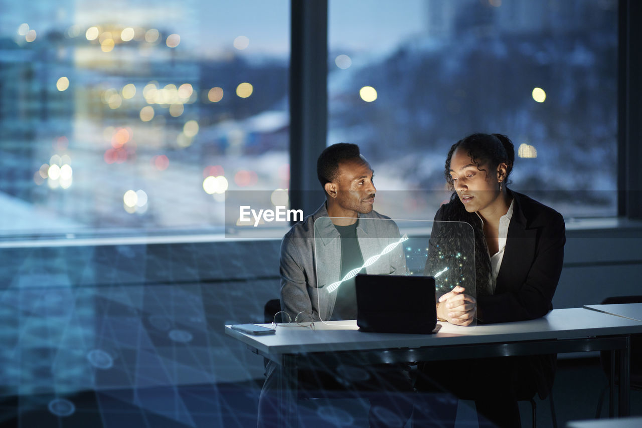 Two young business people working together in office