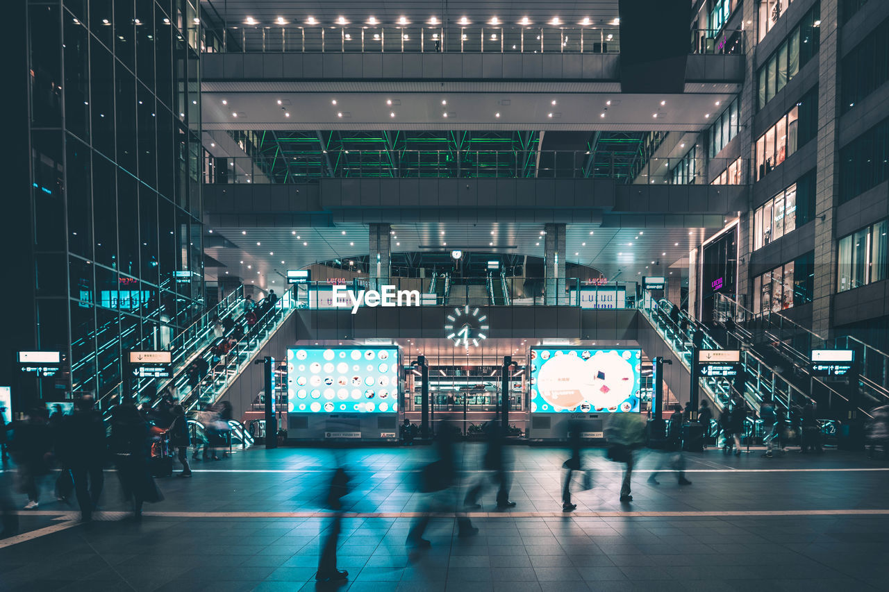 GROUP OF PEOPLE IN ILLUMINATED CITY